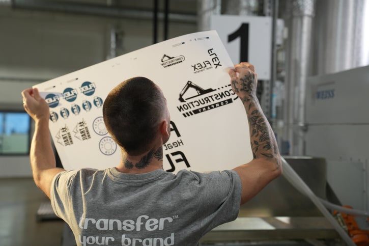 Picture of production staff holding a sheet up to the light